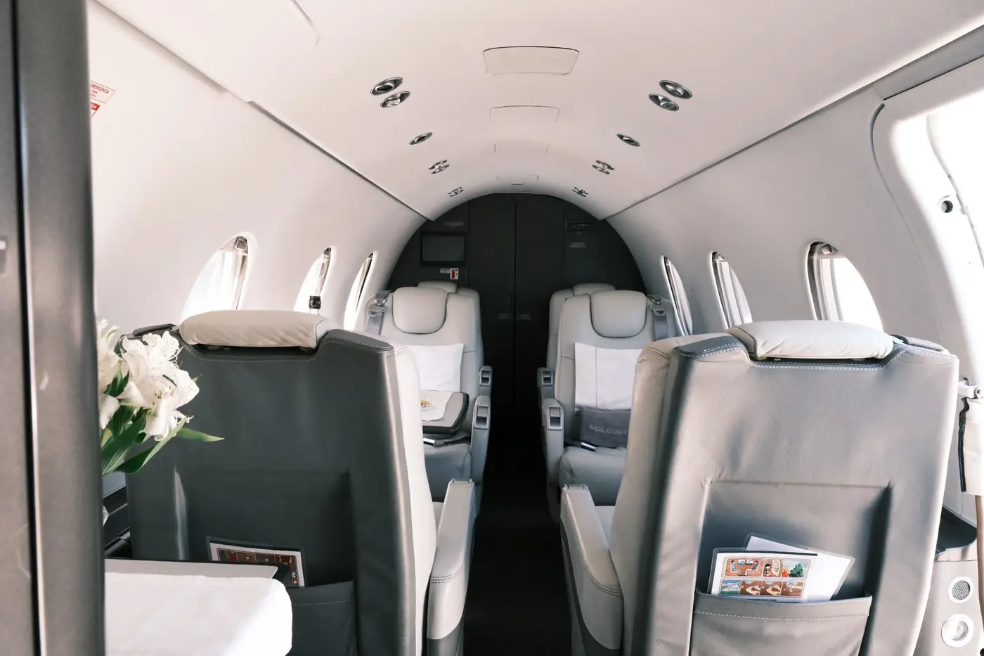 Corredor da cabine do Hawker 400XP, com poltronas em couro claro